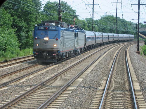 An electric Amtrak train with two AEM-7 locomotives running through New Jersey on the Northeast Corridor. The catenary system is clearly visible