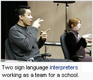 Two sign language interpreters working as a team for a school.