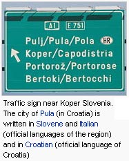 Traffic sign near Koper Slovenia. The city of Pula (in Croatia) is written in Slovene and Italian (official languages of the region) and in Croatian (official language of Croatia)