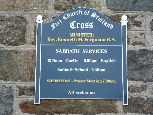 A sign indicating services in Gaelic and English at a Free Church of Scotland