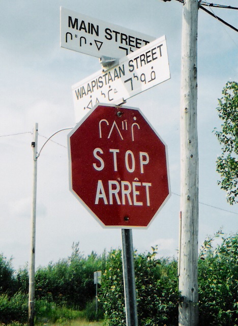 A Quebec stop sign in Cree, English and French.